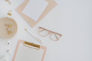 Flatlay blank copy space. Clipboard, clips in rattan plate on white background. Home office desk workspace. Aesthetic business, work template. Flat lay, top view