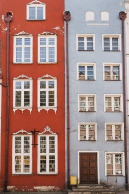 Gdansk, Polonya 'daki eski tarihi mimari. Ahşap pencereleri, panjurları ve renkli pastel duvarları olan geleneksel Avrupalı eski kasaba binaları. Estetik yaz tatili, turizm geçmişi