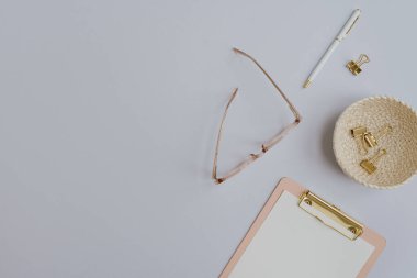 Flatlay boş kopya alanı. Pano, gözlük, pastel arka planda rattan plaka klipsleri. Ofis masası çalışma alanı. Estetik iş, iş şablonu. Düz yatış, üst görünüm