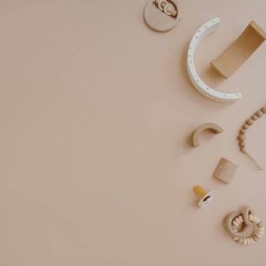 Gökkuşağı dizme oyuncağı, emzik, yumuşak renk arka planında emzik tutucu. Pastel bej rengi şirin İskandinav çocuk oyuncakları ve aksesuarları. Çevrimiçi moda mağazası, alışveriş kavramı