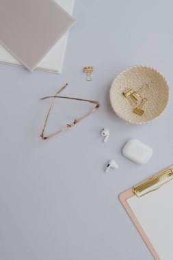 Flatlay boş kopya alanı. Pano, gözlük, kulaklık, pastel arka planda rattan plaka klipsleri. Ofis masası çalışma alanı. Estetik iş, iş şablonu. Düz yatış, üst görünüm