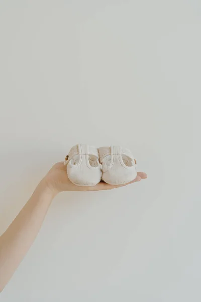 Λευκό Βαμβάκι Χαριτωμένο Παιδικά Παπούτσια Στο Χέρι Των Γυναικών Λευκό — Φωτογραφία Αρχείου