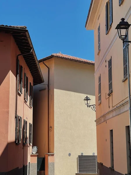 イタリアの古い歴史的建造物 伝統的なヨーロッパの古い町の建物 木製の窓 シャッター 太陽の影を持つカラフルなパステルカラーの壁 審美的な夏休み旅行の背景 — ストック写真