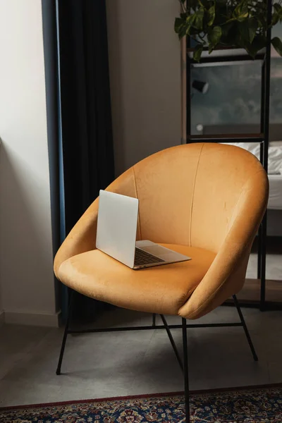 Laptop computer on comfortable orange lounge chair