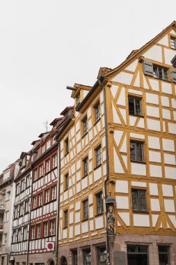 Almanya, Nuremberg 'deki eski tarihi mimari. Ahşap pencereleri, panjurları ve renkli pastel duvarları olan geleneksel Avrupalı eski kasaba binaları. Estetik yaz tatili, turizm geçmişi