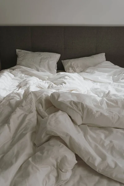 審美的な最小限の家 寝室のインテリアデザイン くぼんだ白いベッドリネン 日光の影のベッド — ストック写真