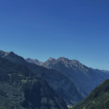 Dağ tepesinin, ormanın, gökyüzünün ve bulutların manzarası. Manzaralı doğa manzarası. Yaz tatili