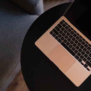 Siyah yuvarlak masadaki Rose Gold dizüstü bilgisayar. Düz yatış, üst görünüm