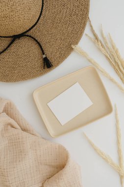 Kağıt kağıtlar, boş kopya alanı, hasır şapka ve beyaz arka planda kurutulmuş otlar.