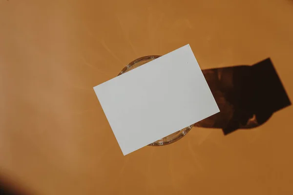 Üres Papírmeghívó Másolási Hellyel Napfény Árnyék Tükröződik Meleg Narancssárga Háttér — Stock Fotó