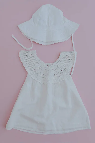 为粉红背景的女婴设计一套可爱的夏装 白色衣服和帕纳马帽 平躺在地上 小宝宝时尚时尚选择的顶视图 — 图库照片