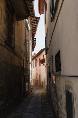 Tarihi antik İtalyan mimarisi. Geleneksel Avrupa eski kasaba sokak binaları. Ahşap pencereler, panjurlar ve renkli pastel duvarlar. Estetik yaz tatili seyahat geçmişi