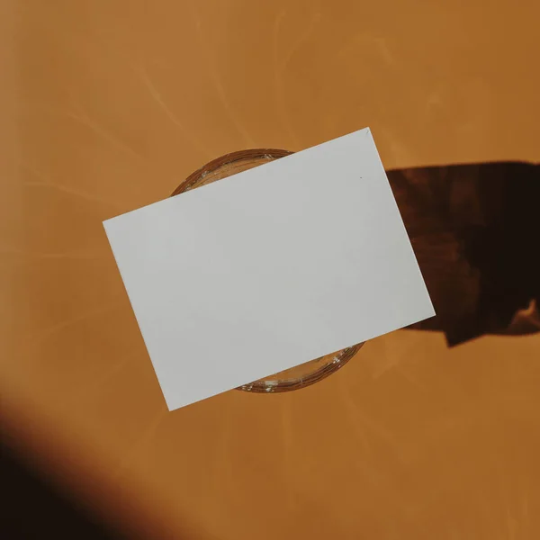 空白纸制卡片 仿制复制空间 橙色背景上的阳光阴影 美感波希米亚最小的商业品牌模板 平躺在地上 俯瞰四周 — 图库照片