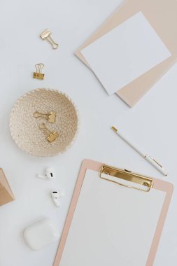 Flatlay blank copy space. Clipboard, clips in rattan plate on white background. Home office desk workspace. Aesthetic business, work template. Flat lay, top view