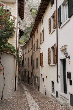 Eski tarihi İtalyan mimarisi. Geleneksel Avrupa köyü kır binaları. Çiçekler, ahşap pencereler, panjurlar ve pastel duvarlar. Estetik yaz tatili seyahat geçmişi