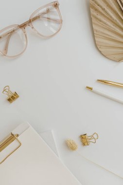 Fan yaprağı sapı, gözlük, pano, beyaz arka planda altın aksesuarlar ve boş kopya alanı. Düz konum, üst görünüm minimalist ofis masası çalışma alanı şablonu