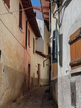 Kırsal İtalyan mimarisi. Geleneksel tarihi Avrupa kır binaları. Ahşap pencereleri, çiçekleri ve çiçek açan ağaçları var. Estetik yaz tatili seyahat kavramı