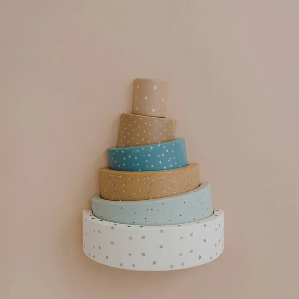 Rainbow stacking toy on neutral soft pastel beige colour background. Flat lay, top view