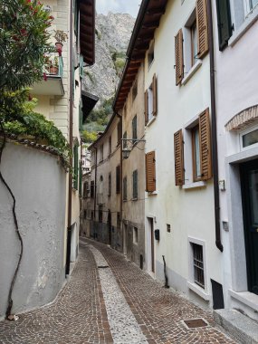İtalya 'daki eski tarihi mimari. Geleneksel Avrupa eski kasaba binası. Ahşap pencereler, kepenkler ve güneş ışığı gölgeli renkli pastel duvarlar. Estetik yaz tatili seyahat geçmişi