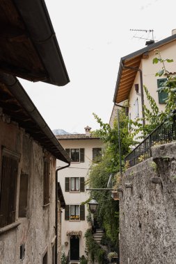 Eski tarihi İtalyan mimarisi. Geleneksel Avrupa köyü kır binaları. Çiçekler, ahşap pencereler, panjurlar ve pastel duvarlar. Estetik yaz tatili seyahat geçmişi
