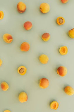 Tarafsız pastel yeşil yüzeyde olgun şeftalilerle yatıyordu.