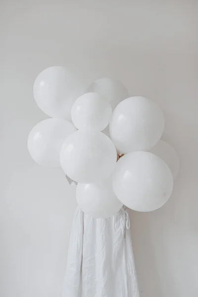 穿着白色衣服的女人拿着一堆白色背景的生日气球 节日庆祝活动的理念 派对时间 — 图库照片