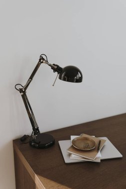 Laptop bilgisayar, lamba ve defterlerle dolu bir ofis. Çalışma, çalışma alanı