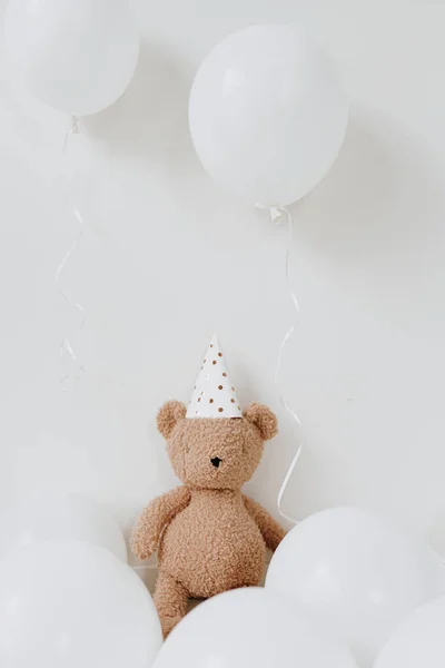 可爱的玩具玩具玩具玩具 戴着派对帽 坐在白色背景的气球旁边 孩子们的生日庆祝活动 宝宝的一周年纪念日 带有空白复制空间的气球 — 图库照片