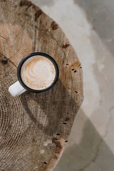 Coffee time! Flatlay mug with latte coffee on wood stump table. Minimalist morning breakfast background. Aesthetic flat lay, top view still life lifestyle concept