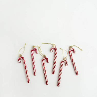 Noel ağacı süslemesi. Beyaz arka planda şeker kamışları. Asgari Noel tatili konsepti. Düz yatış, üst görünüm