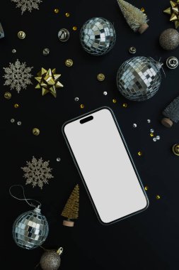 Flatlay cep telefonu, siyah arkaplanda boş fotokopi alanı var. Estetik Noel süslemeleri: disko topları, yıldızlar, konfeti, süsler. En iyi görünüm Yeni Yıl şablonu