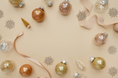 Noel, yeni yıl tatili kompozisyonu. Boş kopya alanı olan çerçeve. Altın noel baloları, tarafsız bej arka planda yıldızlar. Düz yatış, üst görünüm şenlik modeli