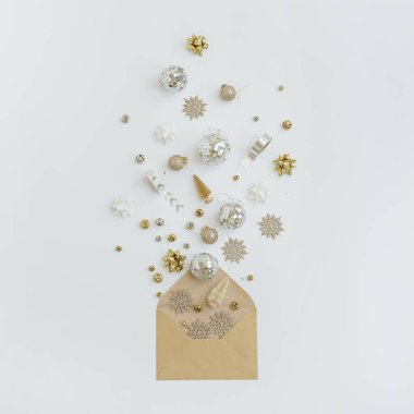 Beyaz zemin üzerinde Noel ağacı süslemeleri, toplar, yıldızlar, kurdeleler olan el işi kağıt zarf