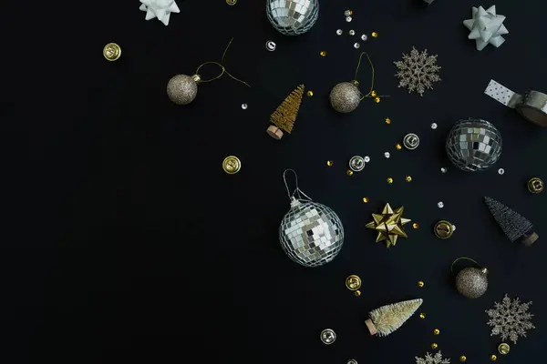 豪華なクリスマス 年末年始のコンポジション ゴールドバブルボール ブラックバックの星 クリスマスツリーの装飾 平らな層 トップビューのお祝いのパターン — ストック写真