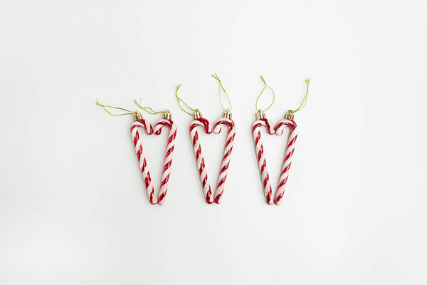 Heart, love symbol made of Christmas candy canes on white background. Minimal festive Christmas concept