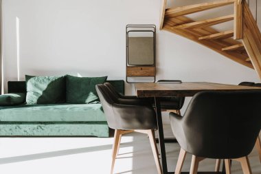 Kanepesi, merdiveni, masası, ayna koltukları olan modern bir ev. Güneş ışığı gölgeleri. İç tasarım konsepti. Kiralık daire