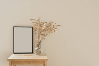 Boş kopya alanına sahip boş fotoğraf çerçevesi ve tarafsız arkaplanda kurutulmuş çimen buketi