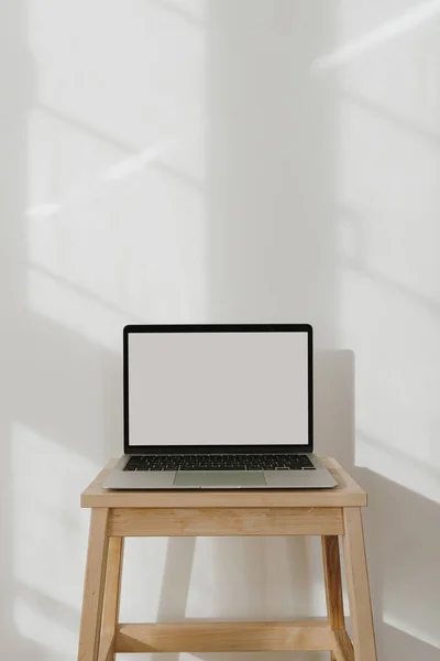 Aesthetic sunlight shadows on the wall. Blank display laptop computer with copy space. Influencer lifestyle blog