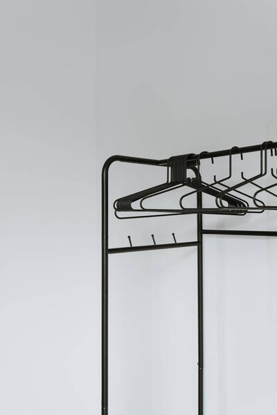 Empty hangers on floor hanger over white wall. Minimalist home interior concept with wardrobe. Online fashion store, online shop background