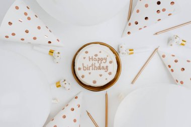 Doğum günü pastası, parti şapkaları, balonlar, beyaz arka planda mumlar. Düz yatış, üst görünüm zarif bayram kutlaması