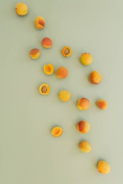 Tarafsız pastel yeşil yüzeyde olgun şeftalilerle yatıyordu.