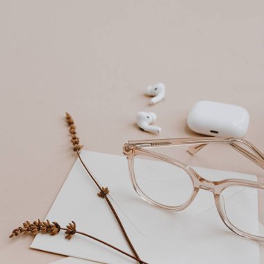 Nötr bronz bej masa üzerindeki minimalist çalışma masası kırtasiyesi. Estetik yaratıcılık konsepti. Mektup yazma