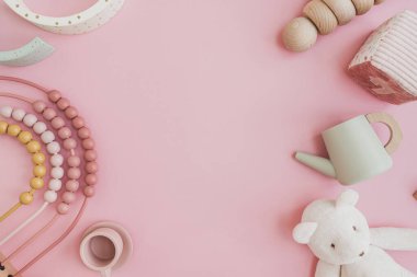Bebek bebek organik doğal tahta oyuncaklar pastel pembe arka planda. Bardaklar, gökkuşağı, mutfak gereçleri. Düz konum, üst görünüm kopyalama alanı uydur
