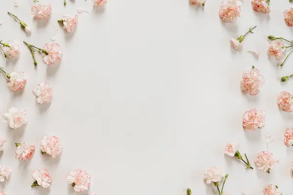ミニマルフラワースタイルのコンセプト コピースペース付きの白い背景にピンクのカーネーションの花 クリエイティブウェディング招待テンプレート フラットレイ トップビュー ストックフォト
