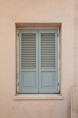 Yunanistan, Oia, Santorini 'de taş bir duvarda kepenkleri olan eski renkli eski bir pencere. Geleneksel Avrupa, Yunan mimarisi. Yaz seyahati