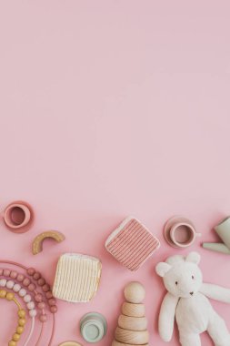 Şık İskandinav bebek oyuncakları. Pastel pembe arka planda ve boş fotokopi alanı var. Oyun ve eğitim için bebek eşyaları. Düz yatış, üst görünüm