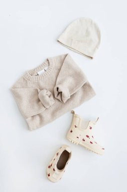 Bebek için tatlı pastel elbiseler ve aksesuarlar. Sıcak giysi: kazak, çizme, şapka. Estetik bebek moda mağazası, alışveriş konsepti