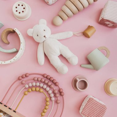 Pastel pembe arka planda İskandinav bebek oyuncakları. Oyun ve eğitim için bebek eşyaları. Düz yatış, üst görünüm