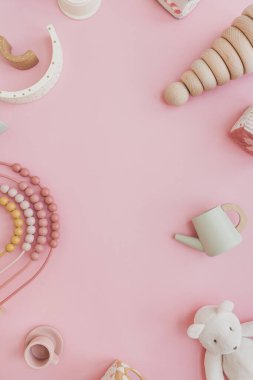 Boş kopya alanı ile düz yatıyordu. Pembe arka planda bebek eşyaları. İskandinav doğal tahta oyuncakları