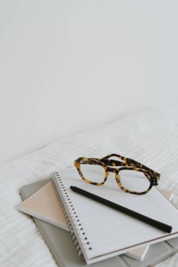 Defter kağıtları, bardaklar, tablet, beyaz kumaşlı kalem. Sanatçı ev ofis çalışma alanı